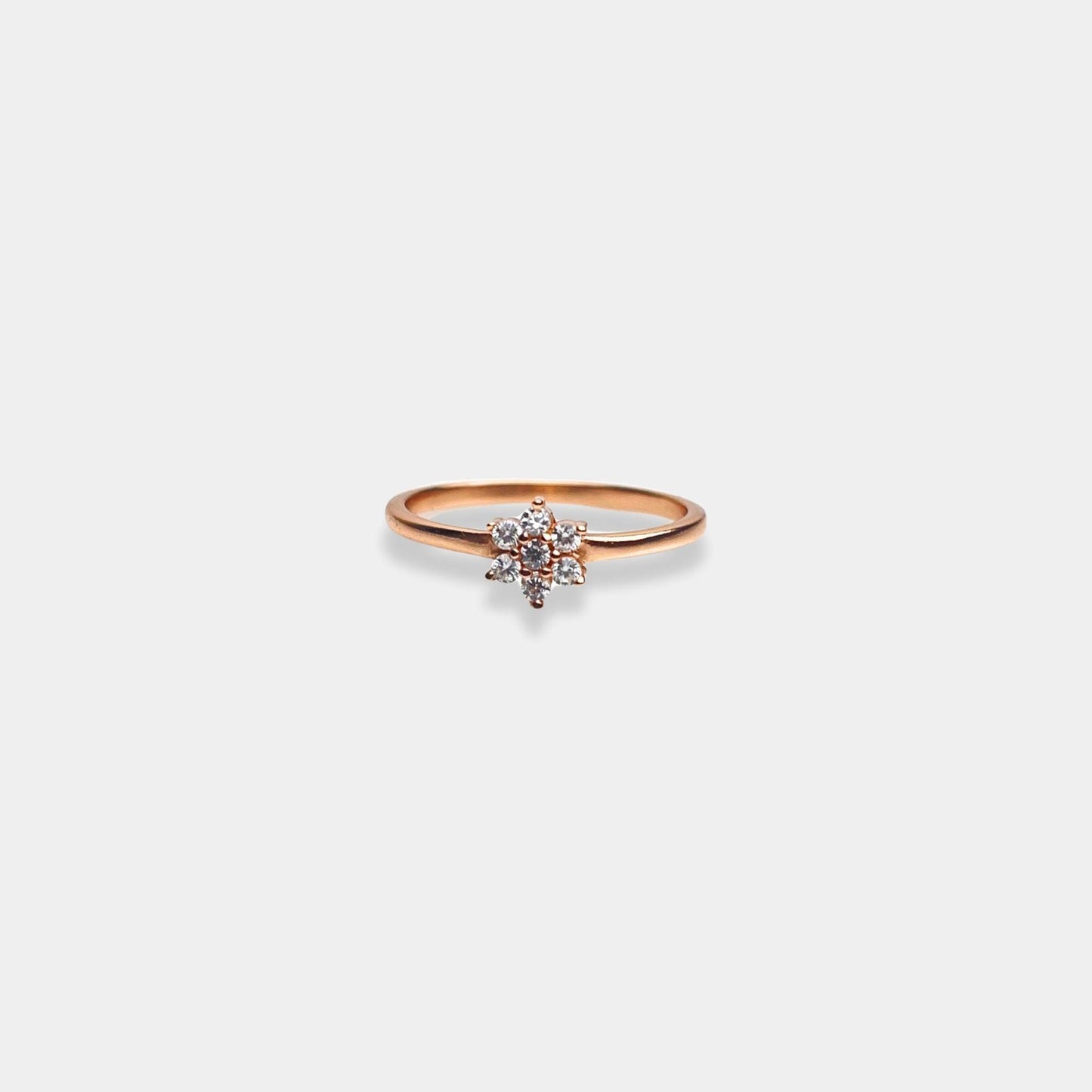 A sterling silver ring with a petite diamond nestled in the center, beautifully crafted in rose gold.