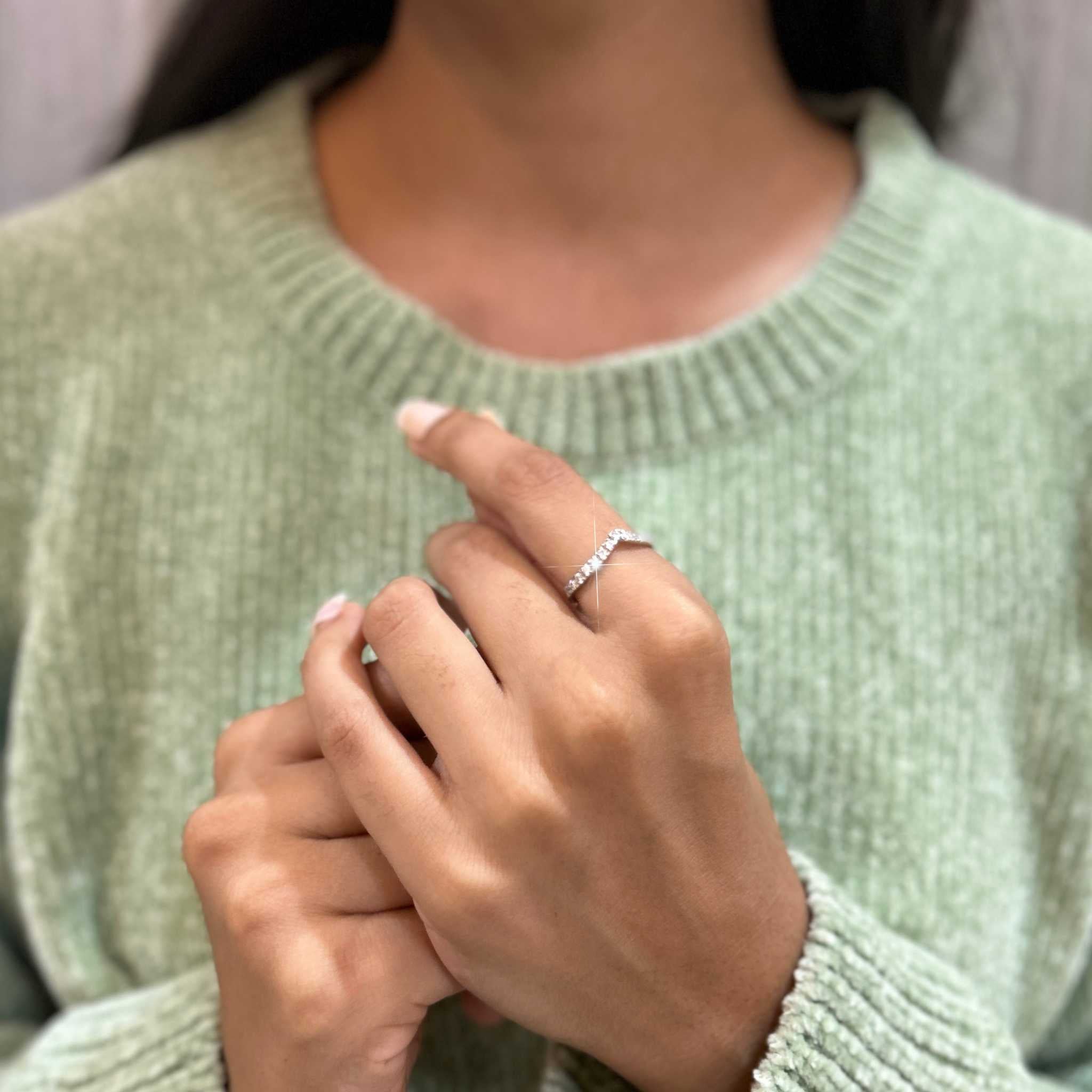 Sparkling silver ring held by a woman's hand on a Stellar silver hypoallergenic V Ring.