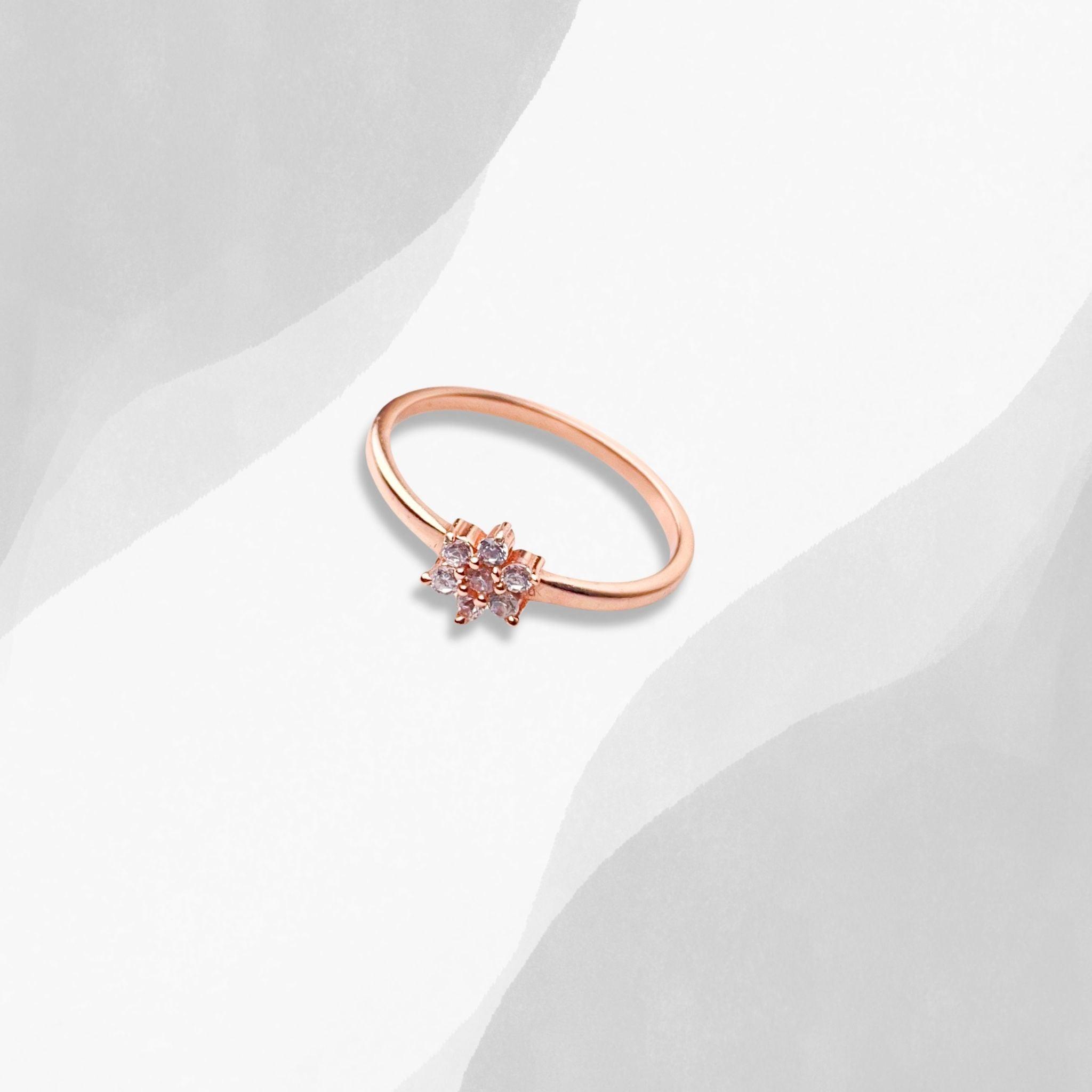 A sterling silver ring with a petite diamond nestled in the center, beautifully crafted in rose gold.