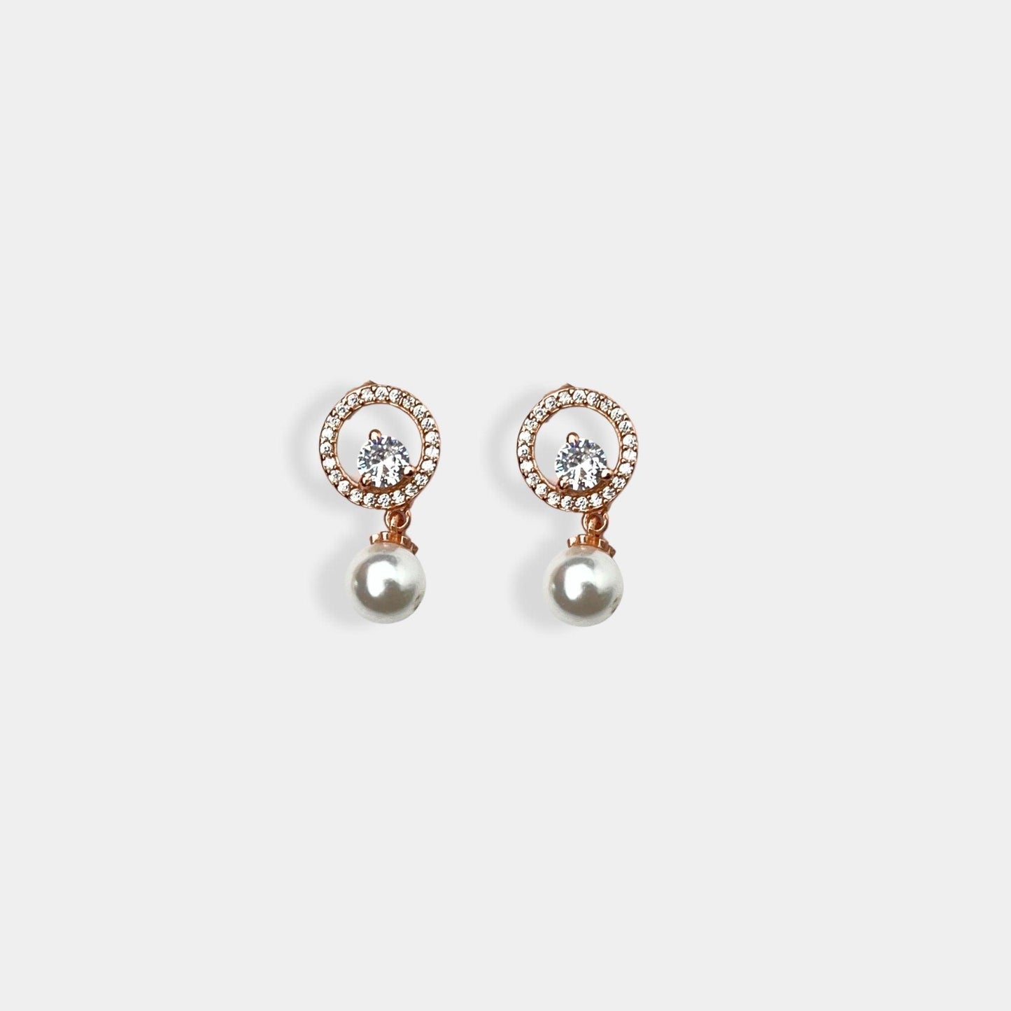  A pair of dainty silver earrings featuring lustrous pearls.