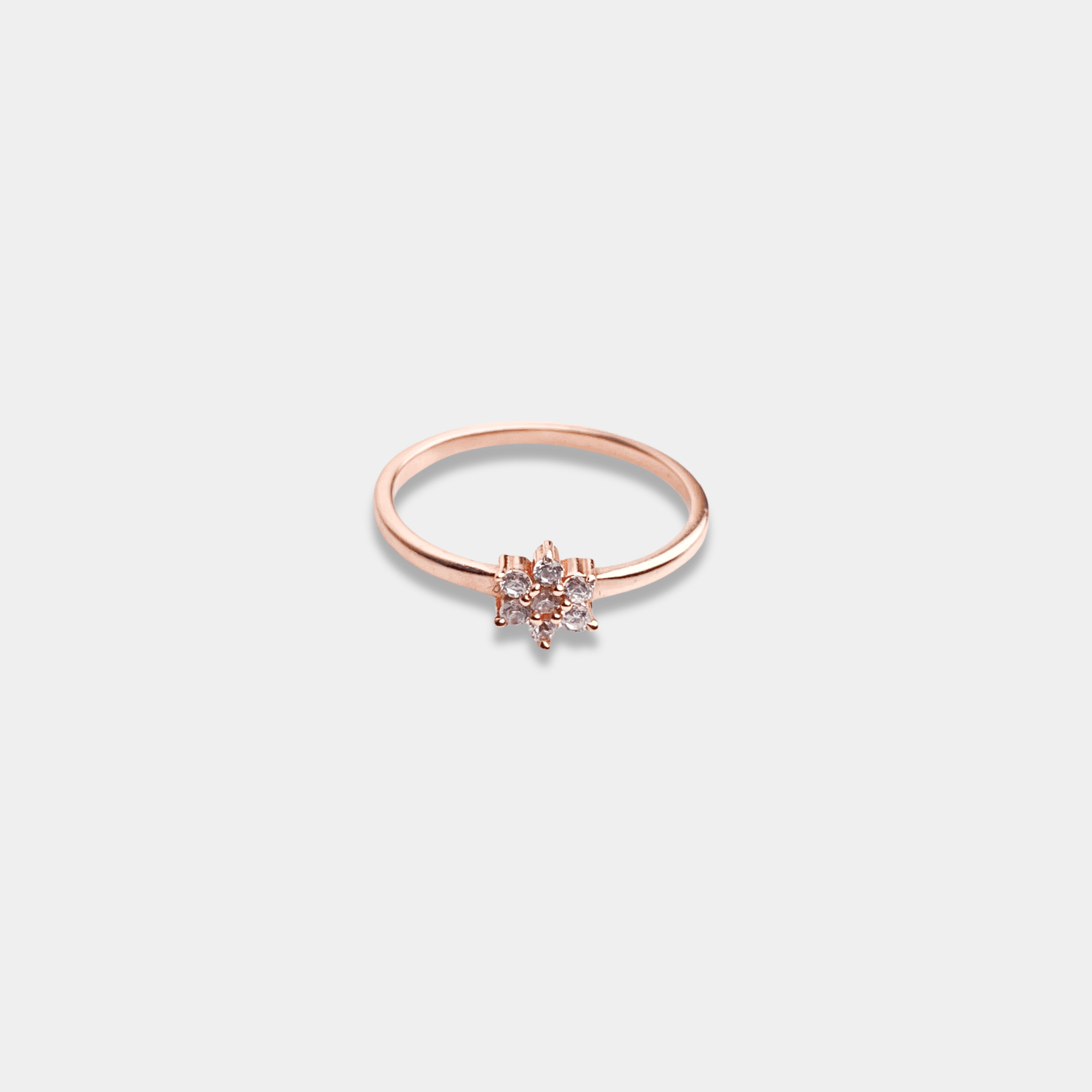 A sterling silver ring with a petite diamond nestled in the center, beautifully crafted in rose gold.