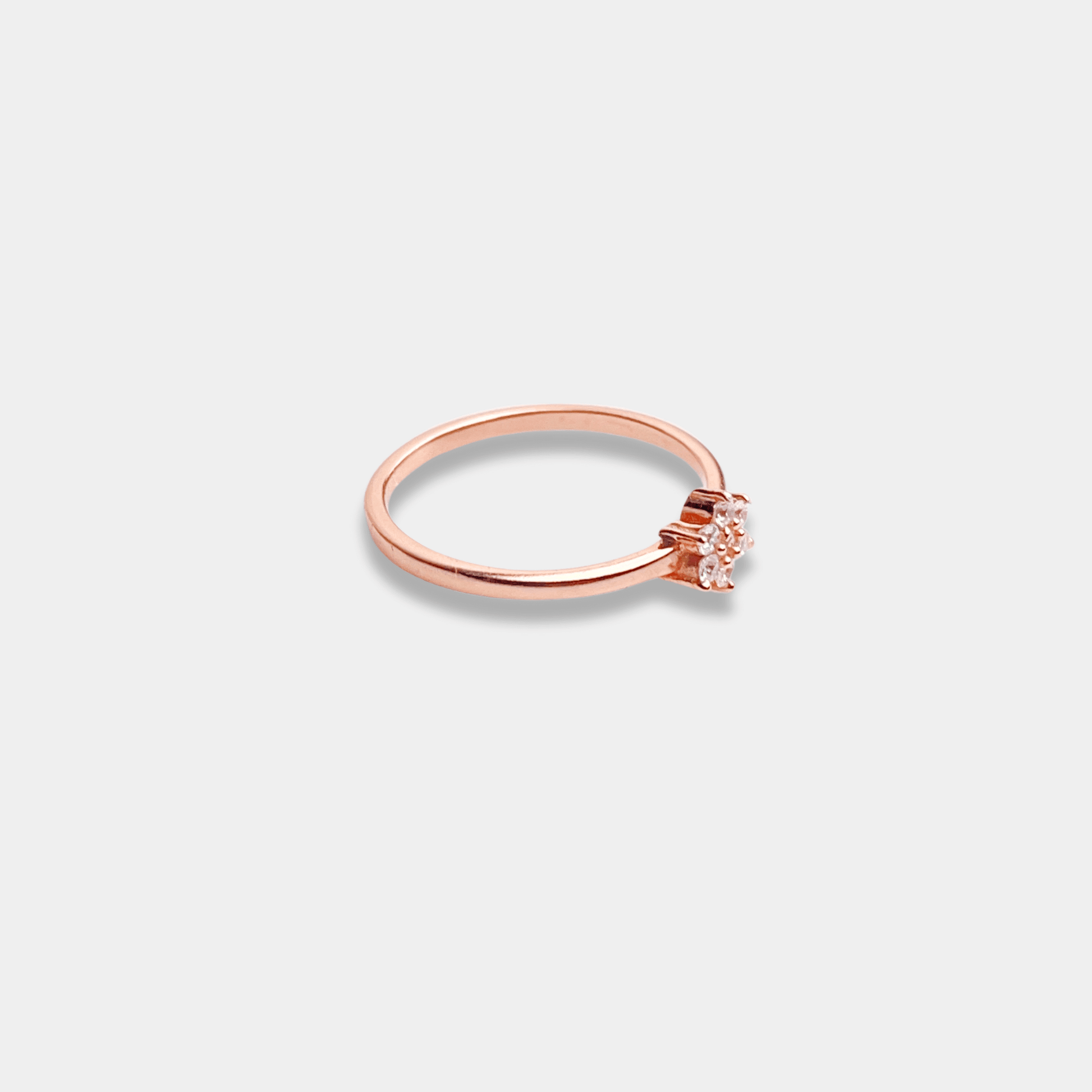 A sterling silver ring with a petite diamond nestled in the center, beautifully crafted in rose gold.A sterling silver ring with a petite diamond nestled in the center, beautifully crafted in rose gold.