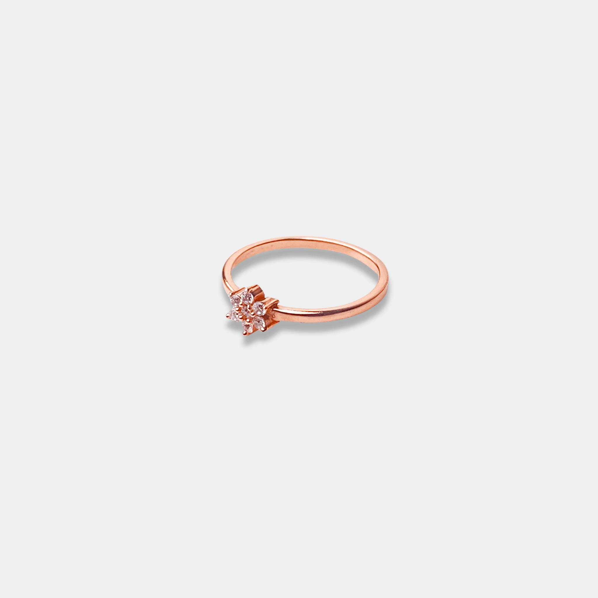 A sterling silver ring with a petite diamond nestled in the center, beautifully crafted in rose gold.