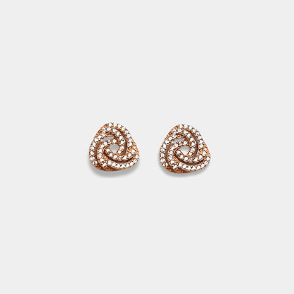 Two diamond stud earrings in rose gold, complemented by a sterling silver ring. Elegant and timeless jewelry pieces